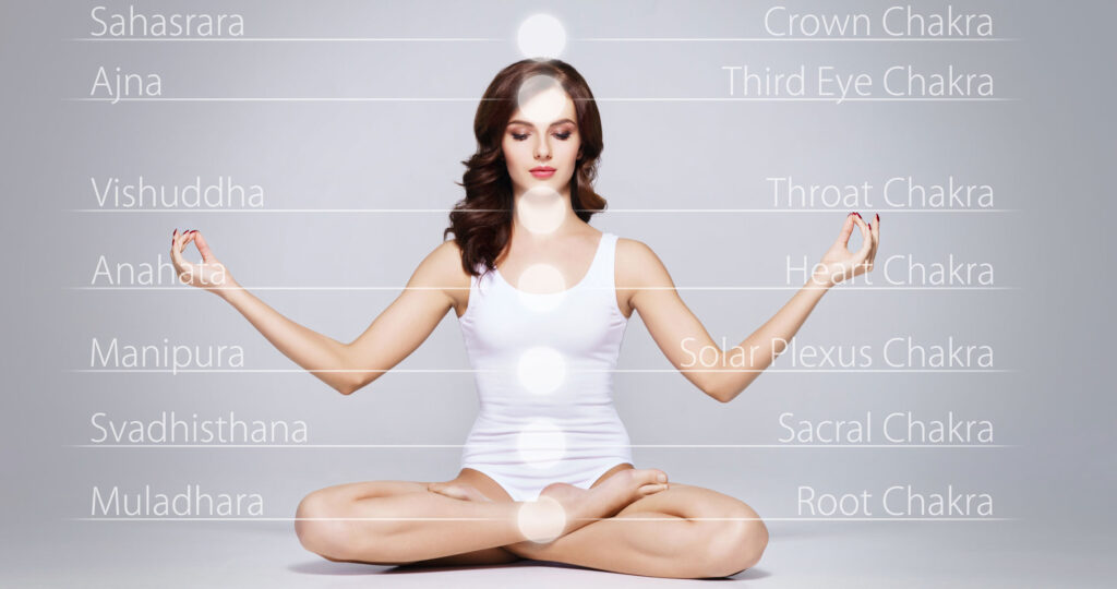 A woman sitting in the middle of her body with her hands in yoga position.