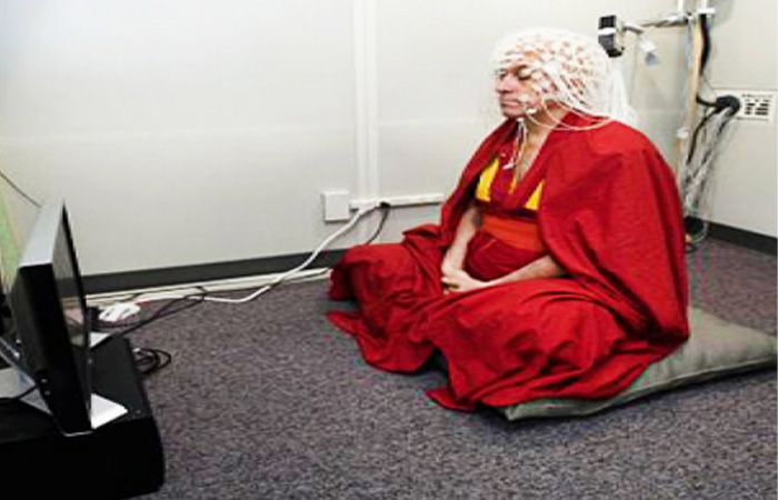 A person sitting on the floor wearing red robes